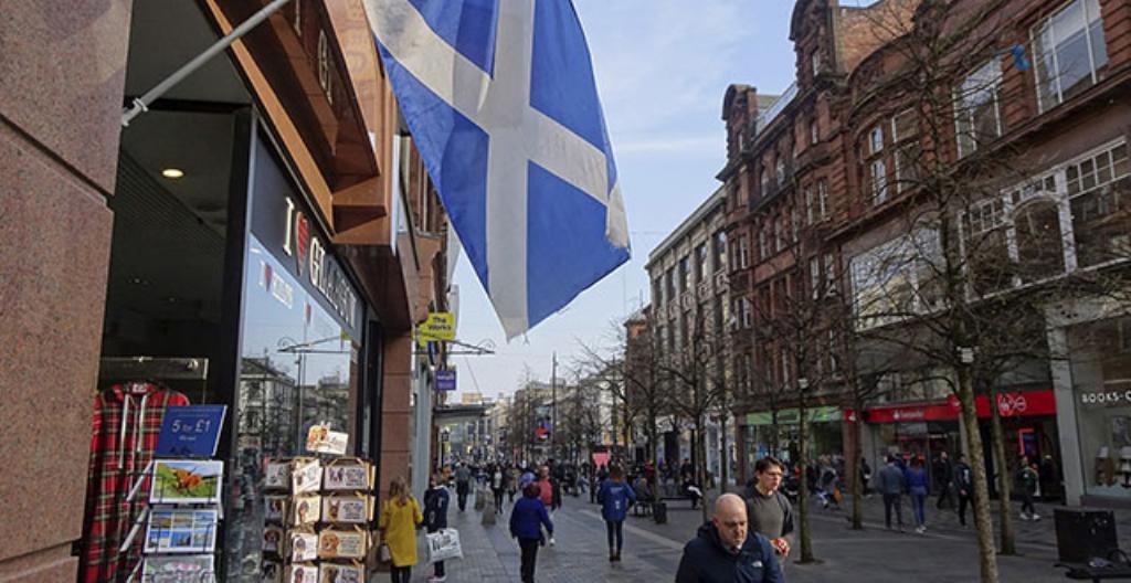 Skottlands blåvita flagga vajar i staden Glasgow.