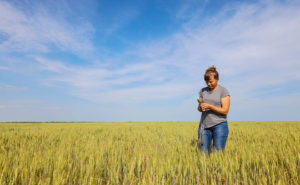 En kvinna står i ett spannmålsfält.