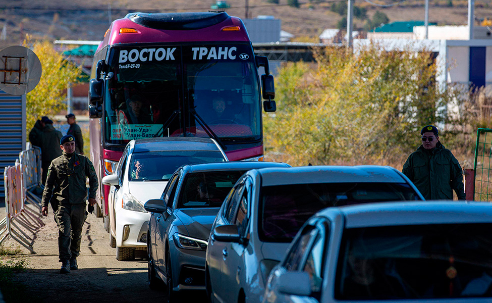 Mongoliska gränsvakter kontrollerar fordon som köat många timmar på väg från Ryssland till Mongoliet. 