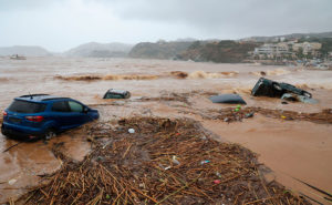 Bilar som dragits ut i havet av översvämmande vatten.