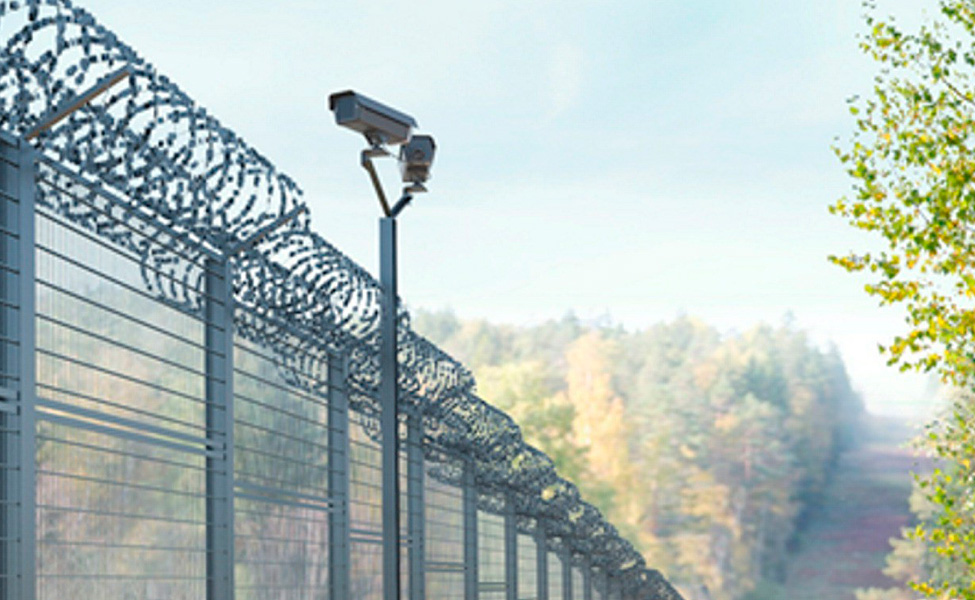 Ett staket av ståltråd och en övervakningskamera.