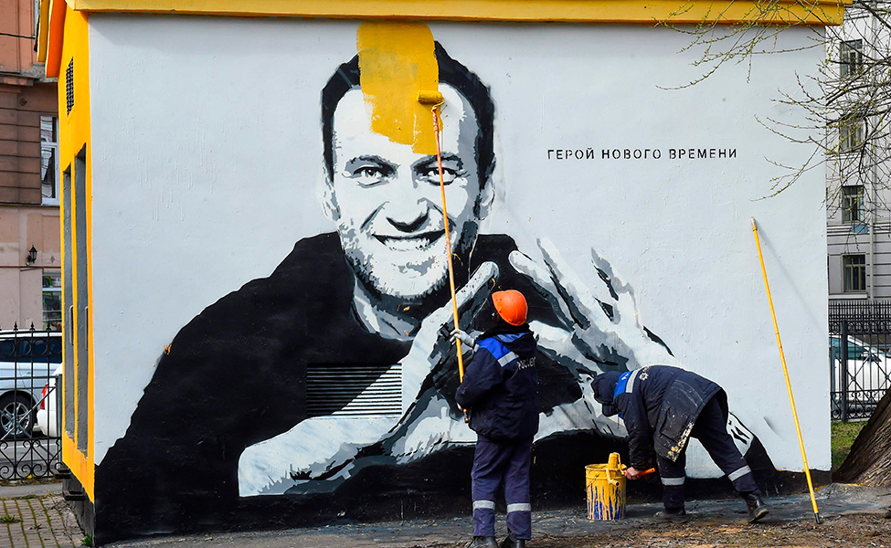 En bild av Aleksej Navalnyj målas över i S:t Petersburg. Navalnyj har kritiserat Vladimir Putins sätt att leda landet.