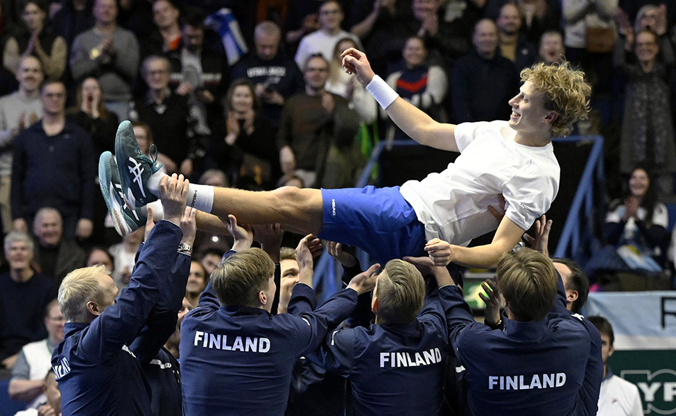 Tennisspelaren Emil Ruusuvuori lyfts upp i luften av sina lagkamrater efter en lyckad match mot Argentina.