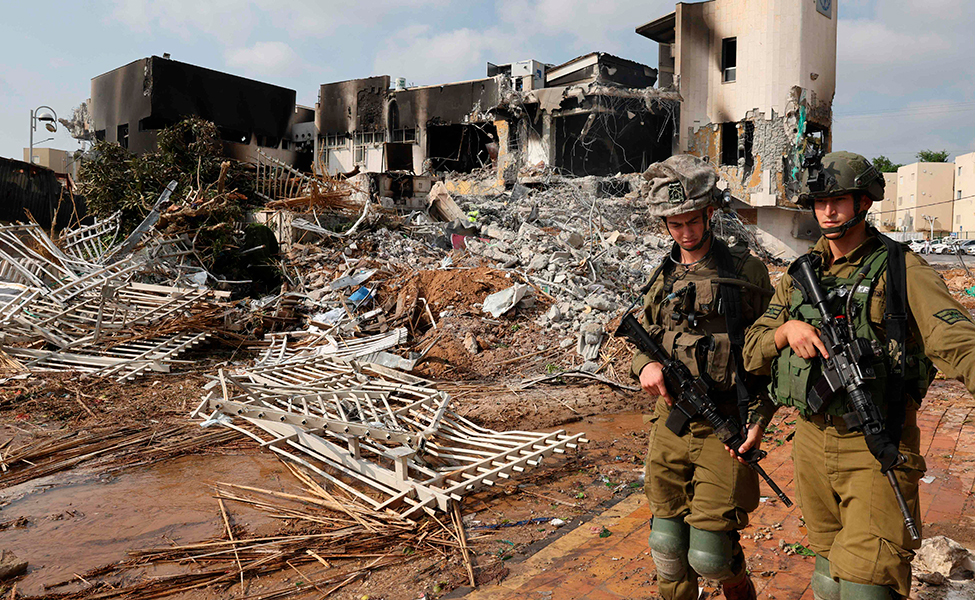 Israeliska soldater går vid en polisstation som förstördes i Hamas attack.
