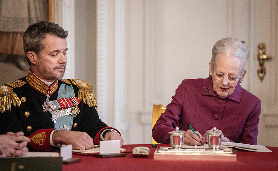 Drottning Margrethe skriver under ett papper om att hon abdikerar. Efter det är hennes son Frederik kung.