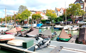 Vy där man ser en kanal med båtar och hus i bakgrunden.