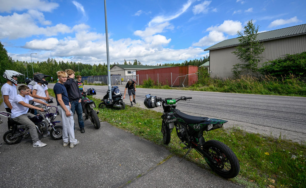 Ungdomar samlades i Tusby nära den plats där en ung mopedist körde av vägen när han jagades av polisen. I bakgrunden syns staketet som mopedisten krockade med.