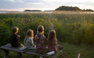 barn sitter på en bänk utomhus.