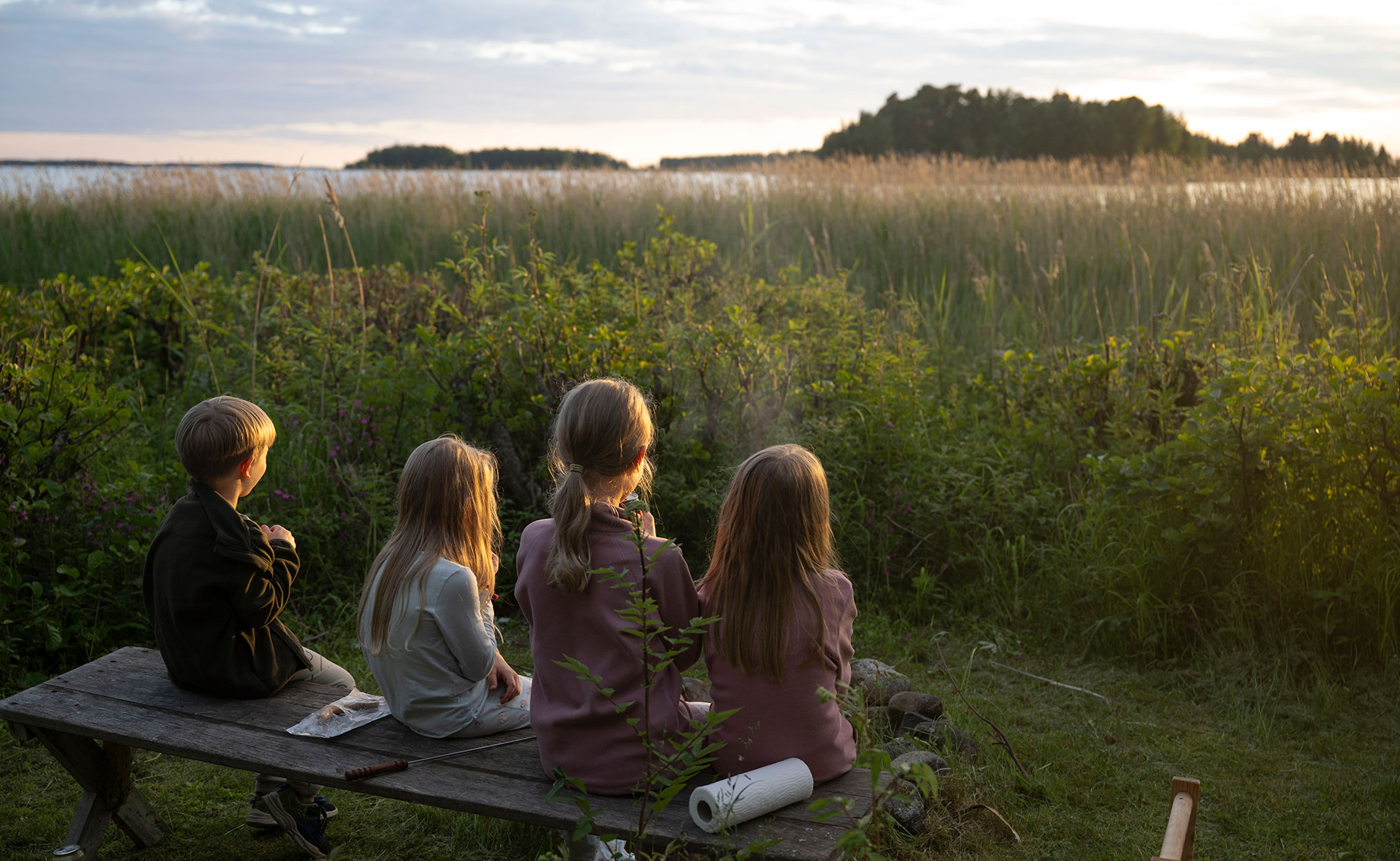 barn sitter på en bänk utomhus.