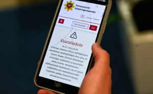 På bilden syns en smarttelefon. på telefonens skärm syns ett varningsmeddelande från myndigheterna. Varningsmeddelandet handlar om risk för drönare och att man ska hålla sig inomhus tills faran är över.